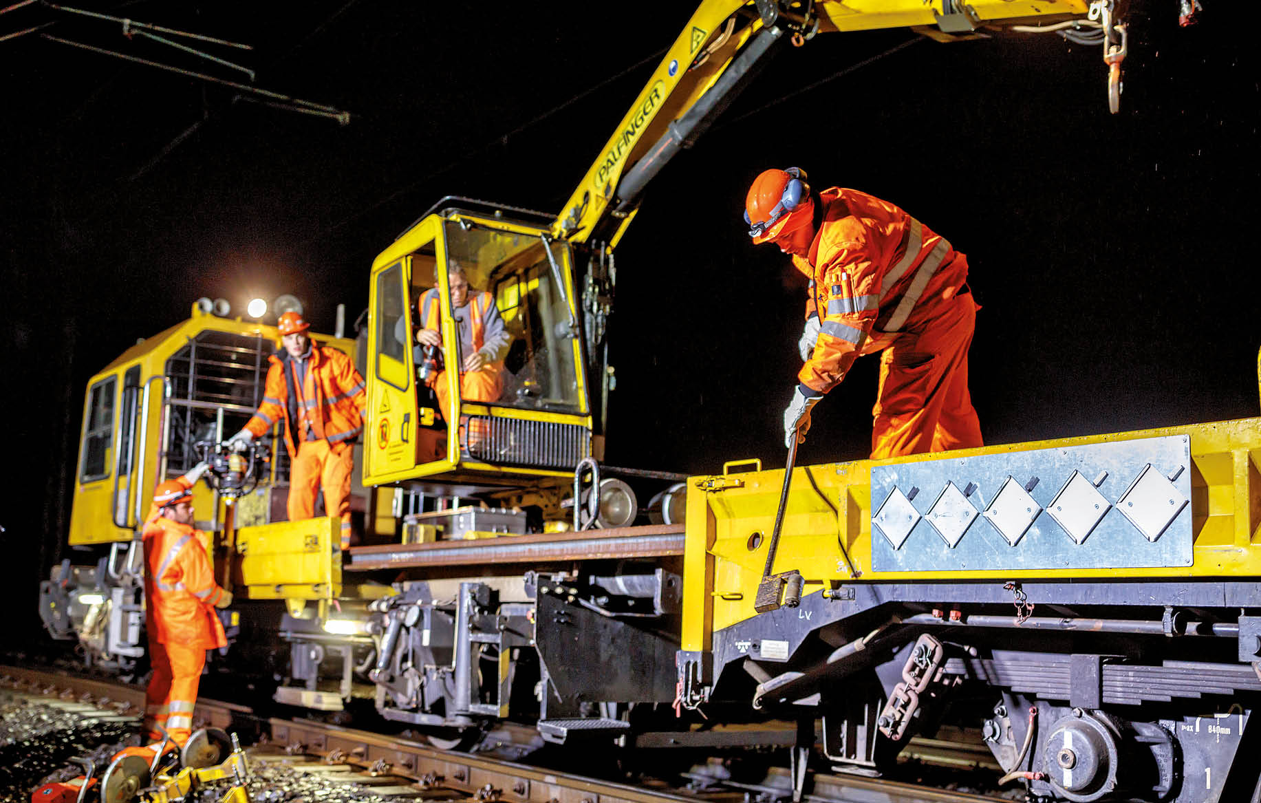 Bauarbeiter auf einer Gleisbaumaschine