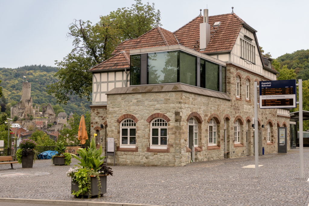 Bahnhofsgebäude von Eppstein mit dem historischen Stadtbild im Hintergrund