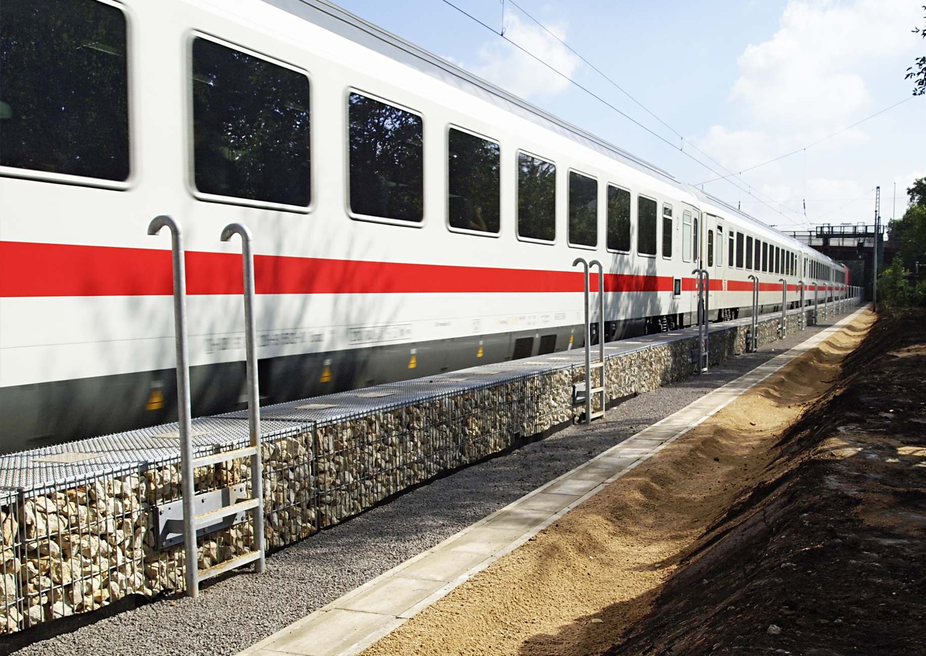 Zug fährt an Schallschutzwaand vorbei