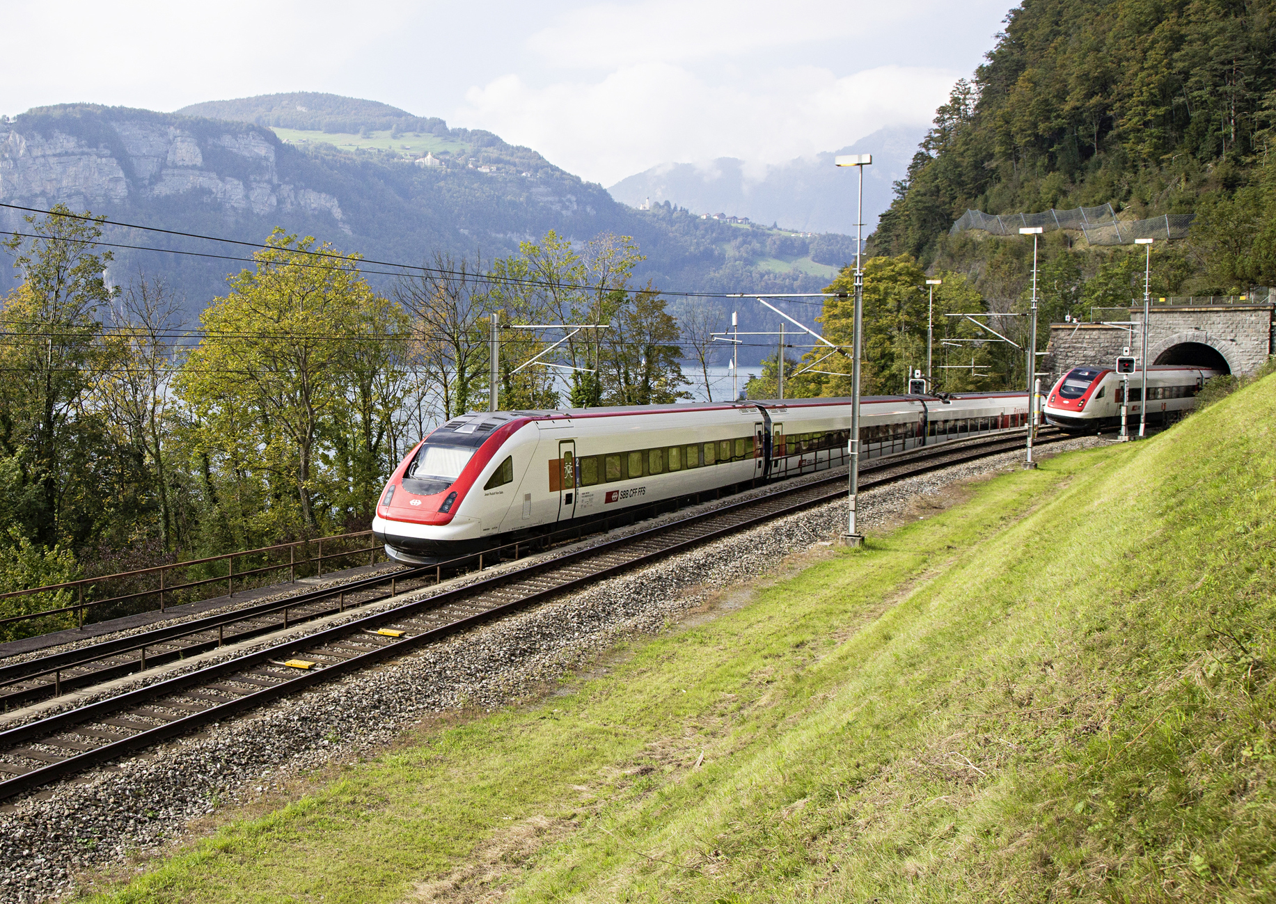 zwei Fernzüge der SBB bei der Ein- und Ausfahrt in einen Tunnel