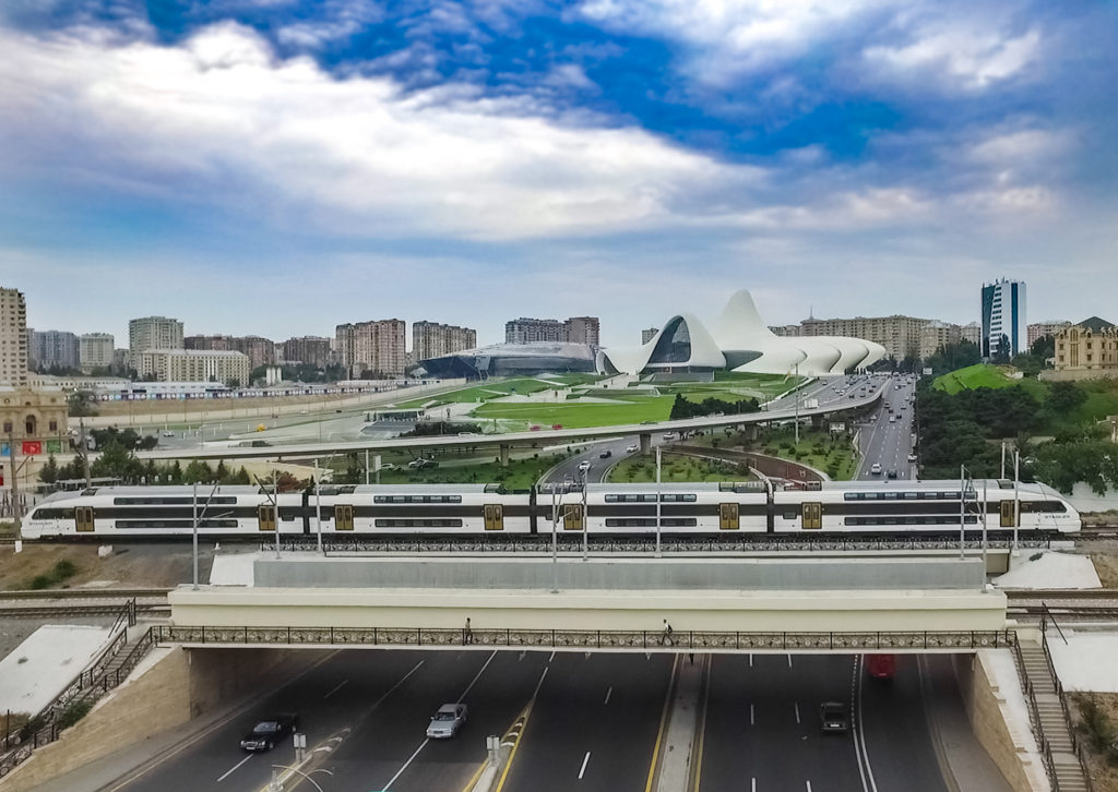 Ein Zug vor dem Hintergrund der Stadtkulisse von Baku