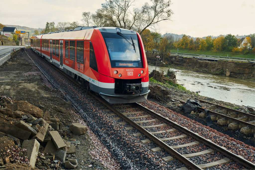 Regionalzug unterwegs neben Flusslauf