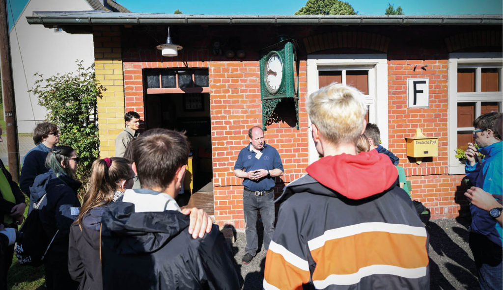 Personengruppe vor einem Bahnhofsgebäude