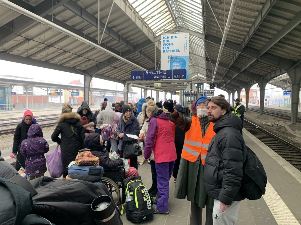 Menschen mit Gepäck auf einem Bahnsteig