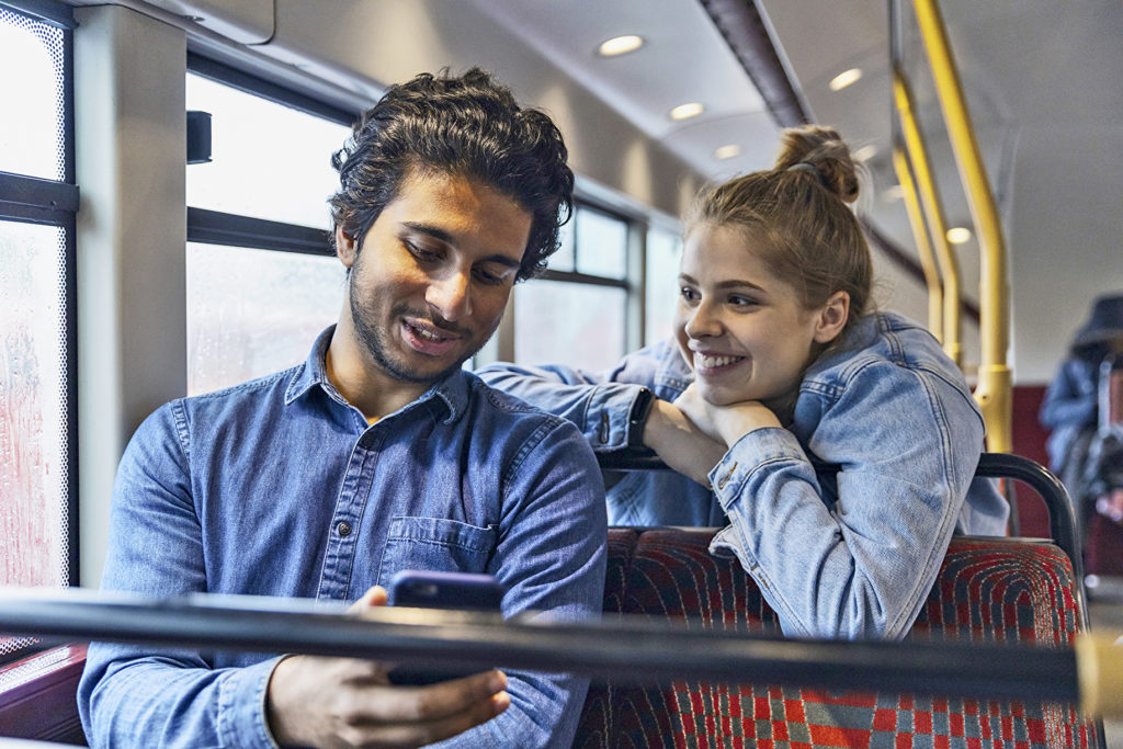 Jugendliche mit Handy in einem Bus