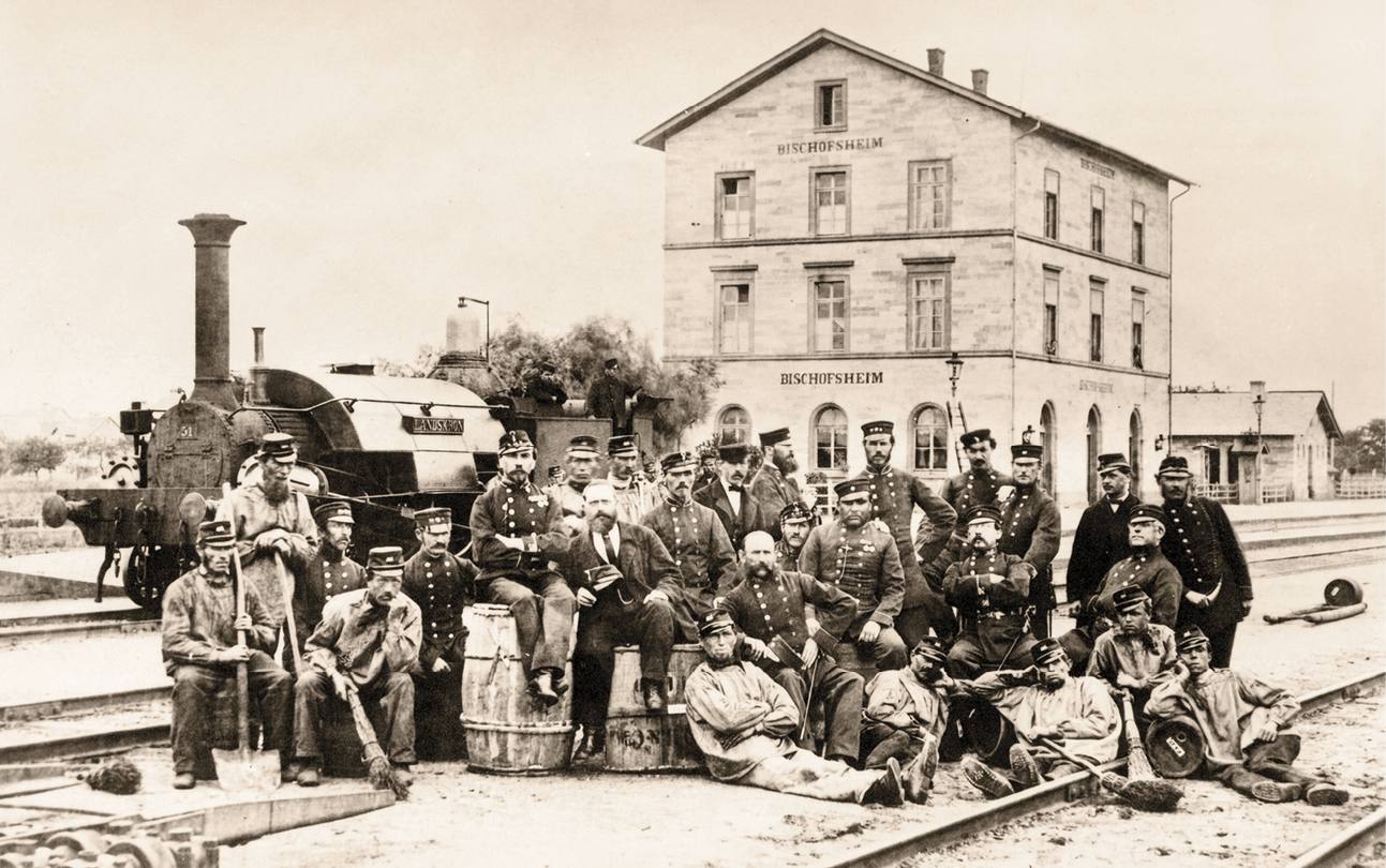 Bahnhofspersonal in Bischofsheim mit der Rangierlokomotive „Landskron“ (Aufnahme aus dem Jahre 1867)