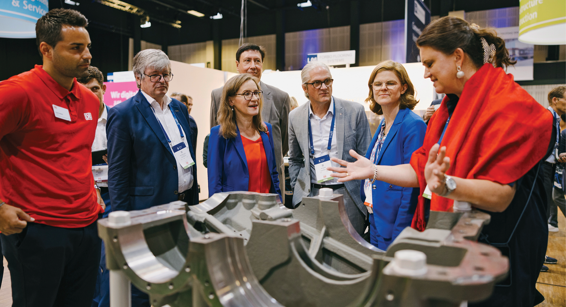 Innovationen für die Bahnbranche: Die DB-Manager Hans Peter Lang, Sigrid Nikutta, Rolf Härdi, Jan Grothe und Daniela Gerd tom Markotten (Bildmitte, von links) begutachten beim Rundgang durch die Ausstellung ein Bauteil aus dem 3D-Drucker, präsentiert von Stefanie Brickwede (rechts)