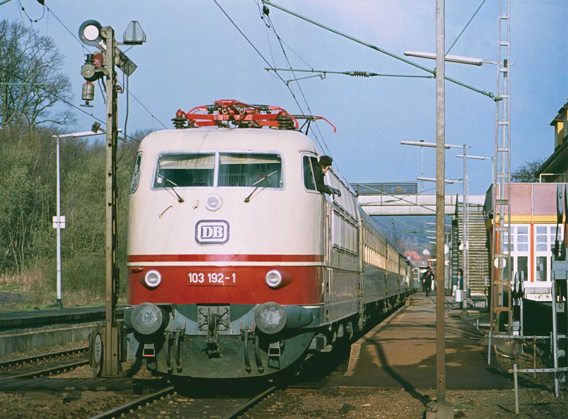Lok der Baureihe 103 vor einem Nahverkehrszug im Bahnhof Egestorf/Deister (April 1977)